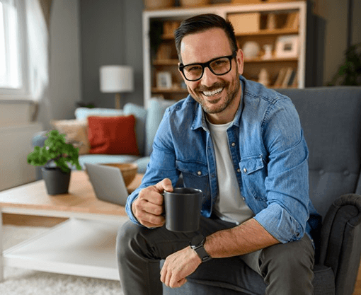 a man with dental crowns enjoying a cup of coffee