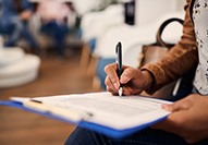 Patient filling out dental insurance form on lobby