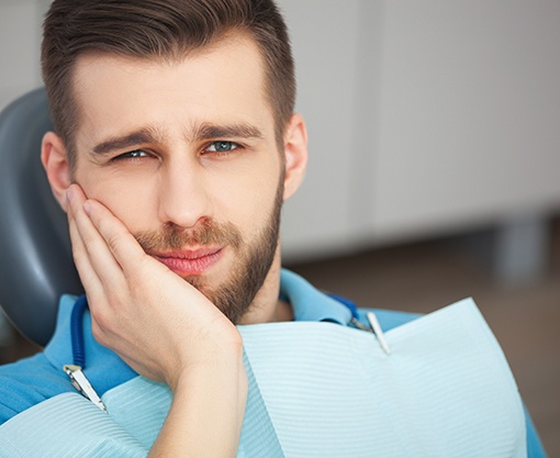 Man with tooth pain visiting emergency dentist in Carmel, IN