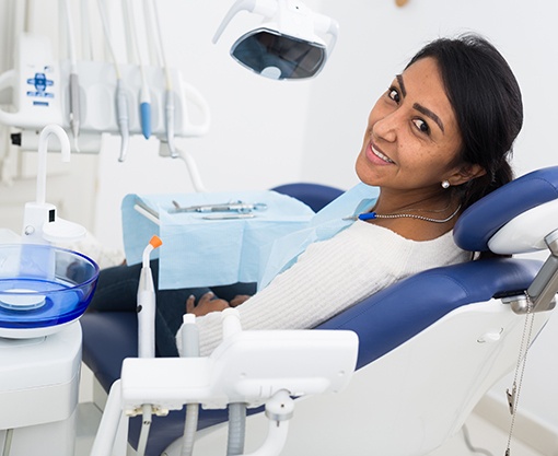 Female dental patient looking back in chair and smiling