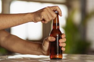 Man popping the cap off a beer
